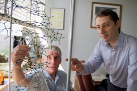 Bogdan Fedeles (right), a research associate in the MIT Department of Biological Engineering and lead author on a new paper on the link between chronic inflammation and cancer, examines a DNA model with professor John Essigmann, who led the current research.