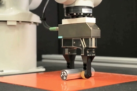 A simple robotic gripper can adjust its grip using the environment. Here, a robot grips a rod lightly while pushing it against a tabletop. This allows the rod to rotate in the robot’s fingers.