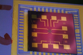 A completed chip with a wired graphene oxide gas sensor. The graphene oxide film is the greenish dot covering the electrode structure.
