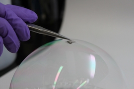 The MIT team has achieved the thinnest and lightest complete solar cells ever made, they say. To demonstrate just how thin and lightweight the cells are, the researchers draped a working cell on top of a soap bubble, without popping the bubble. 
