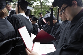 Students look at their new diplomas on MIT's Commencement Day