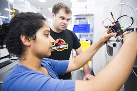 Ginkgo Bioworks staff members Ramya Prathuri (left) and Nate Tedford work at the mass spectrometer in the Ginkgo foundry.
