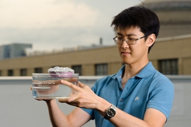 MIT graduate student George Ni holds a bubble-wrapped, sponge-like device that soaks up natural sunlight and heats water to boiling temperatures, generating steam through its pores.
