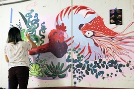 Rising junior Jessie Wang, the AR Coordinator for The Borderline Mural Project, paints a section of the wall.
