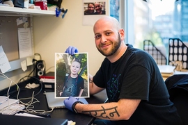 Ryan Kohn, a PhD candidate in the MIT Biology Department’s Jacks Lab, holds a photo of his son, Jayden.
