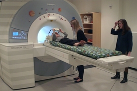 MIT graduate student Hilary Richardson helps a child into an MRI scanner for a study of how children's brains develop the ability to think about the mental states of other people.