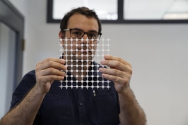 Jose Gomez-Marquez, co-director of MIT’s Little Devices Lab, holds a sheet of paper diagnostic blocks, which can be easily printed and then combined in various ways to create customized diagnostic devices.