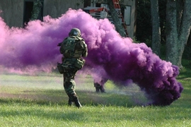 This cloaking grenade, used for hiding troop operations from view on the battlefield, is an example of nanoparticles that reflect a particular color of light based on their exact size and composition. New work by MIT researchers provides a way to predict the light-scattering properties of layered nanoparticles – or to design particles to match a desired type of light-scattering behavior.