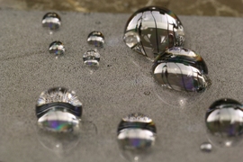 Demonstrating the ability of the material to withstand condensation, this photo shows that the droplets maintain their round shapes even as the surface begins to be covered by newly forming dewdrops, which are seen as a speckled pattern on the surface.