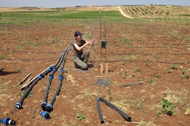 At a treated wastewater irrigation site in Jordan, Julia Sokol installs a datalogger and sensors to record pressure and flow data in irrigation pipes.