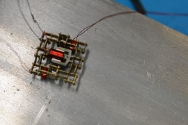 This walking microrobot was built by the MIT team from a set of just five basic parts, including a coil, a magnet, and stiff and flexible structural pieces.