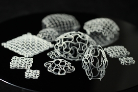 A set of lattice structures that has transformed into spherical caps, or dome-like shapes, after application of a temperature difference. The individual samples range from 3x3 cells to 20x20 cells, with further variations cell sizes and rib dimensions.