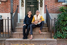 MIT economists Esther Duflo and Abhijit Banerjee sit outside their home. 
