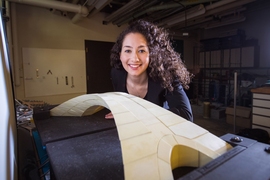 Recent graduate student Karly Bast shows off the scale model of a bridge designed by Leonardo da Vinci that she and her co-workers used to prove the design’s feasibility.