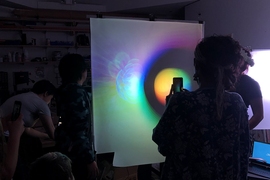 Prathima Muniyappa (with camera) and other class members examining a student demo. In studying various ambiguous images and works, students discover how emotional content and prior experiences contribute to what we think we see. 