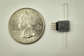 Photo shows the device the team developed. The tube at top is connected to a supply of the precursor material, sodium nitrite, which then passes through a channel in the fiber at the bottom and into the body, which also contains the electrodes to stimulate the release of nitric oxide. The electrodes are connected through the four-pin connector on the left.