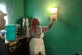 A Lesotho woman turns on a light in her home