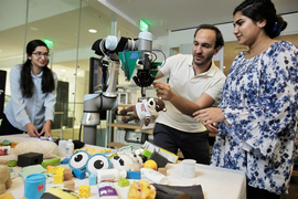 researchers with a robot arm