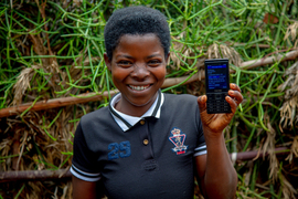 a donation recipient holds up their mobile bank account