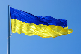 Ukrainian flag blows against a clear blue sky