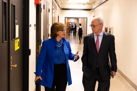 Valerie Jarrett, left, chats with President Reif while walking down an MIT hallway.
