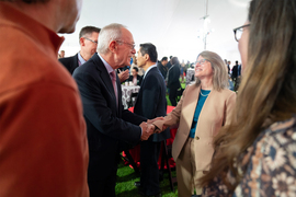 Rafael Reif speaking with Sally Kornbluth in a crowd