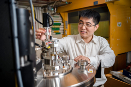 Liu adjusts a part on the sputtering deposition system in the lab.
