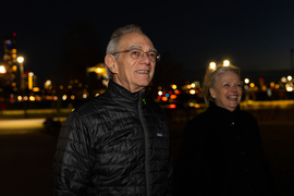 President Reif and his wife smile while looking up at the dome in Killian Court at night