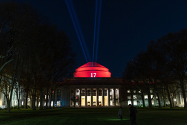 MIT's illuminated Great Dome and hallways glow in a dark night sky as seen from Killian Court