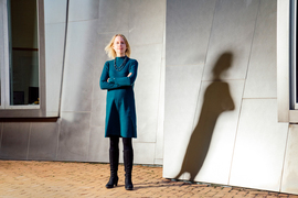 Stefanie Jegelka stands outside of the Stata center, with her dramatic shadow cast on the building.