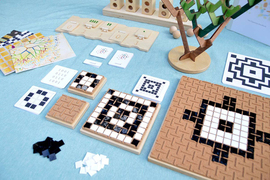 A mixture of games of various sizes, including notched gameboards where you can make designs with black and whites. One toy is a modular tree you can build using smaller wooden pieces.