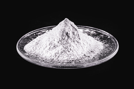 A mound of white powder sits atop a glass plate.