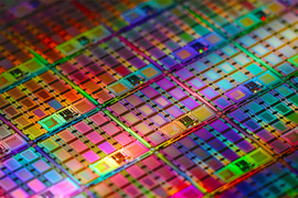 The colorful, rainbow-lit surface of the wafer is made up of a grid of small rectangular amplifiers.