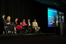 Six people sit on stage in conversation. Sunita Satyapal, in center, is speaking. A screen in the background says, “The Role of Hydrogen in Achieving a Zero Carbon Economy.” 