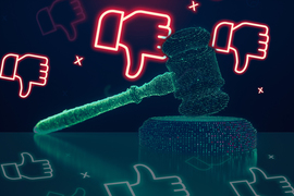 A stylized rendering of a green judge’s gavel rests on a reflective surface. Red “thumbs down” icons are on top in the background, and green “thumbs up” reflections are on bottom of the image.
