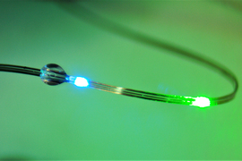 A flexible fiber emitting blue and green light