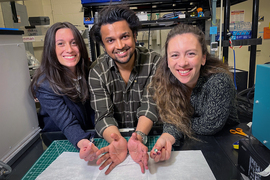 Laura Rupprecht, Atharva Sahasrabudhe, and Sirma Orguc hold parts of their invention in a lab.