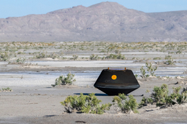 A black NASA orb-shaped capsule in the Utah desert during daytime
