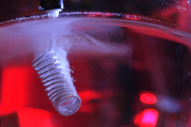 Inside liquid, a tightly coiled electrode makes tiny bubbles.