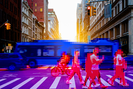 A busy city intersection where a bus is colored blue and pedestrians are colored red.