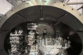 A side view of the LIGO instrument shows its curved ceiling, and some parts of the instrument are taller and stacked.