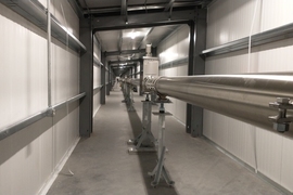 An incredibly long LIGO hallway has a long metallic tube going down it.