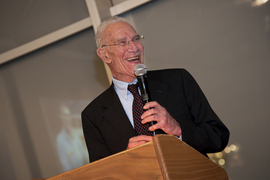 Closeup of Robert Solow speaking at a lecturn, holding a microphone, in 2011