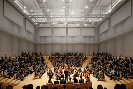 Rendering of MIT Music Building Performance Hall space with musicians performing in the center of the room surrounded by the audience.