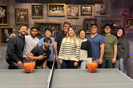 Stitch3D team pose for a photo at a ping-pong bar.