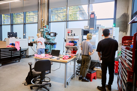 Several people working on equipment and large machinery at MIT’s Engine Accelerator