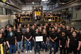 A group photo shows over 50 members of the Boston Metal company.