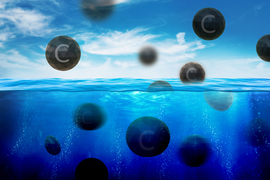 Black spheres with the letter “C” on them float out of the water.