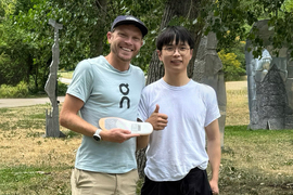 Jake Riley holds a prototype of the sole next to Axl Chen outside.