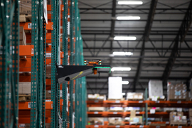 A drone sitting on a small platform in a warehouse
